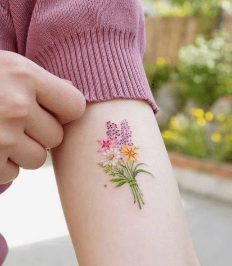 Microrealistic daisy flower tattoo located on the