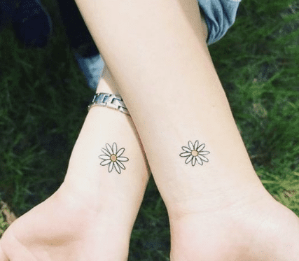 Tiny daisy tattoo on the ankle.