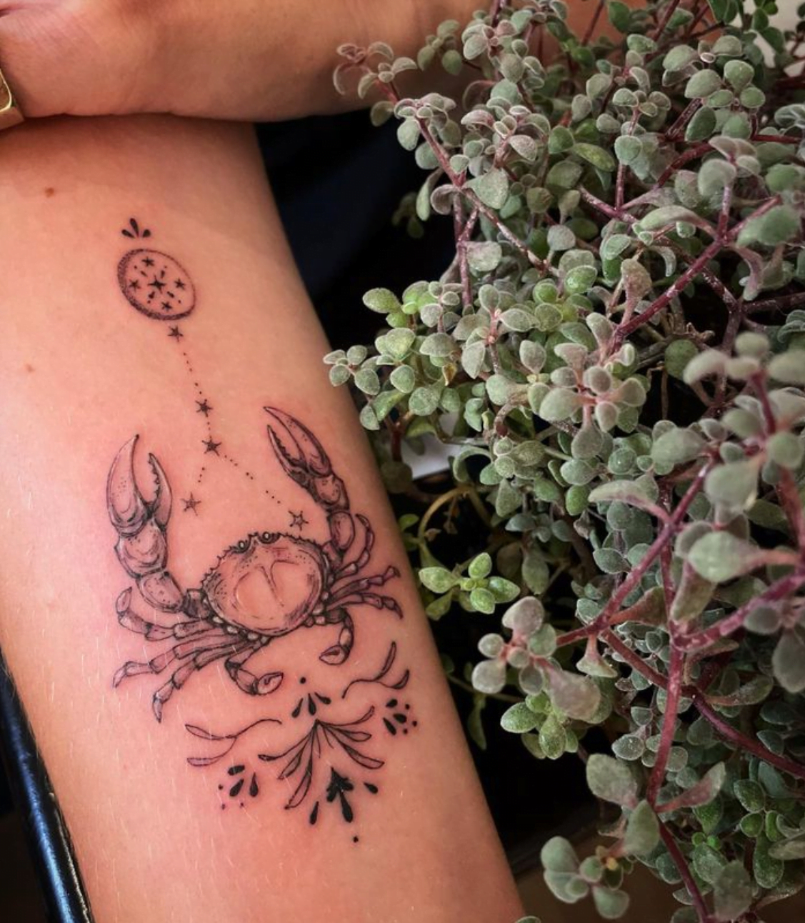 Cancer constellation tattoo on the wrist.