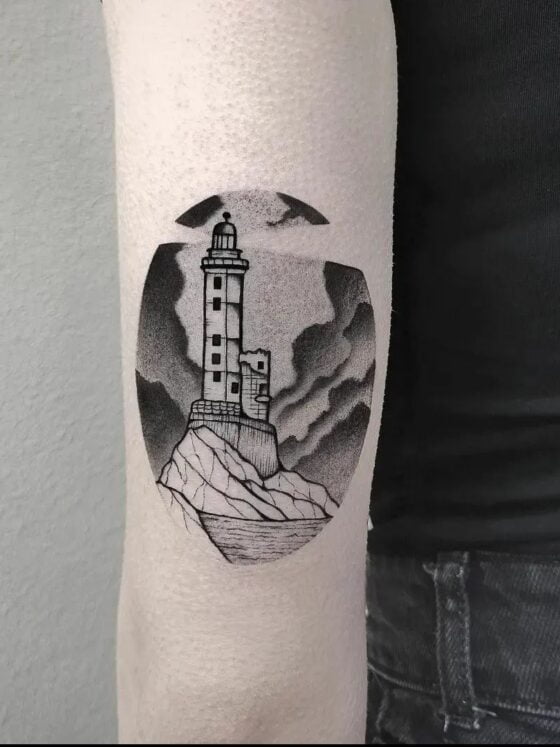 23 Bright Lighthouse Tattoos To Gaze Into 8 lighthouse tattoo with clouds and sea visible