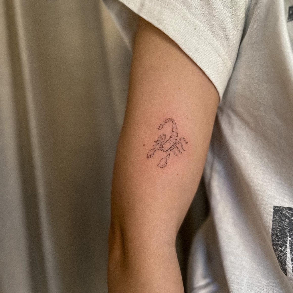 Minimalist Scorpio zodiac symbol tattoo on the wrist.